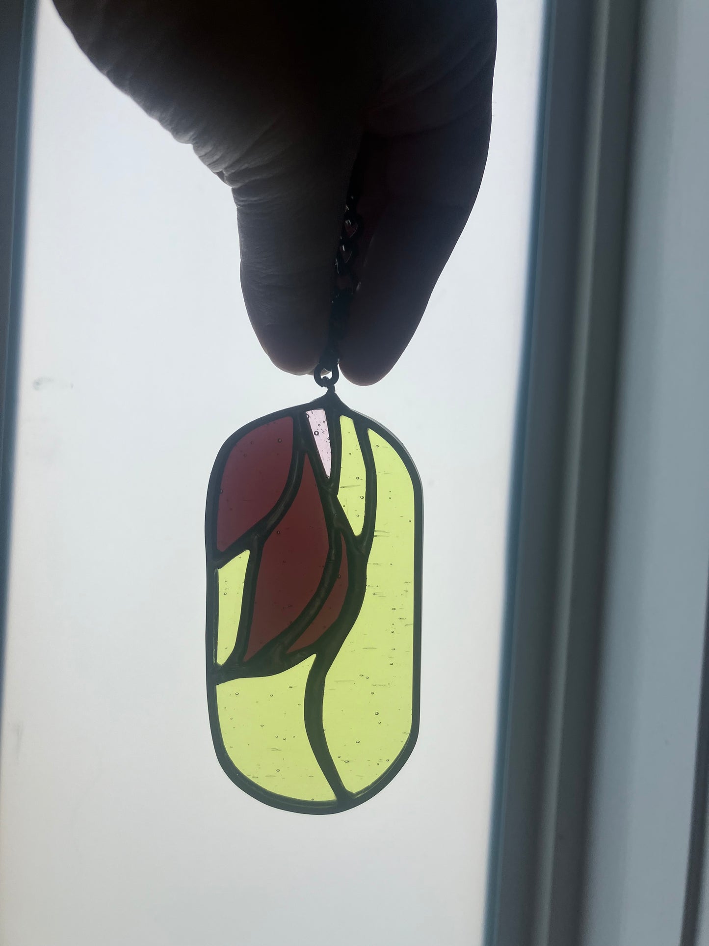 Wilted flower pill-shaped sun catcher - green, mauve and pink